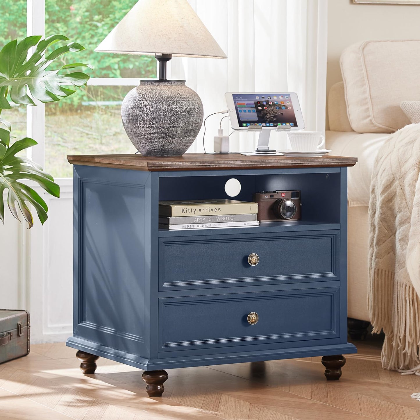 Navy blue 5-drawer dresser with brass knobs and a lamp on top