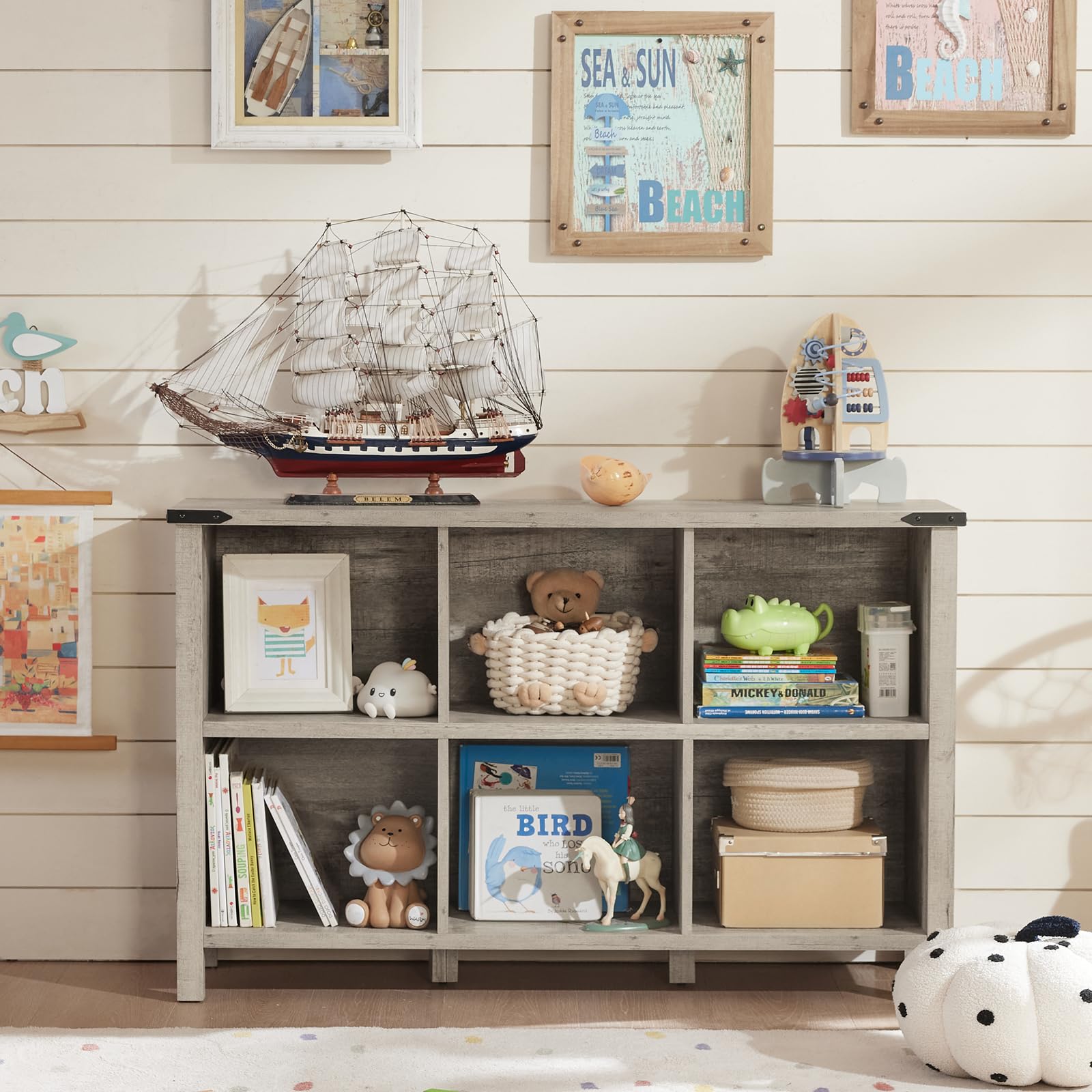 Grey farmhouse bookcase with open cubbies holding books and decor items on legs