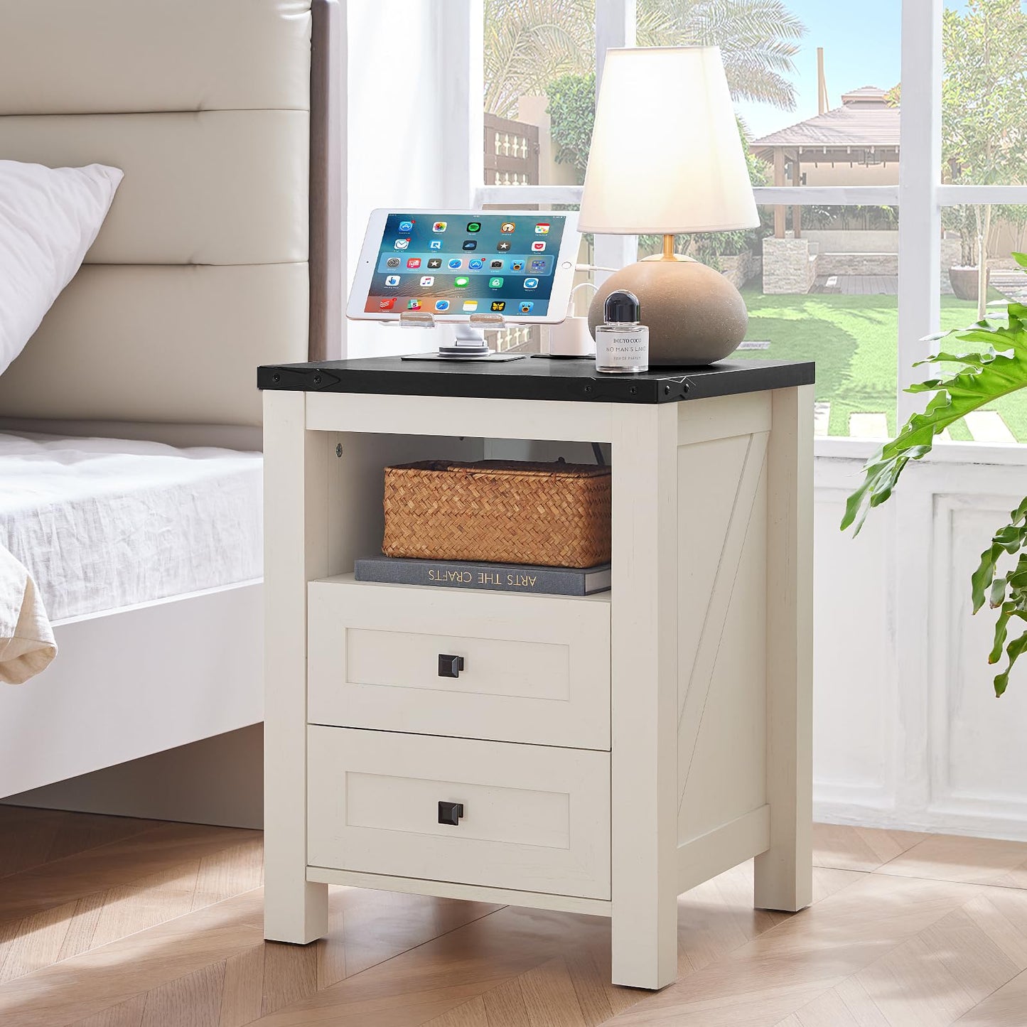 White nightstand with open shelf and two drawers beside a bed