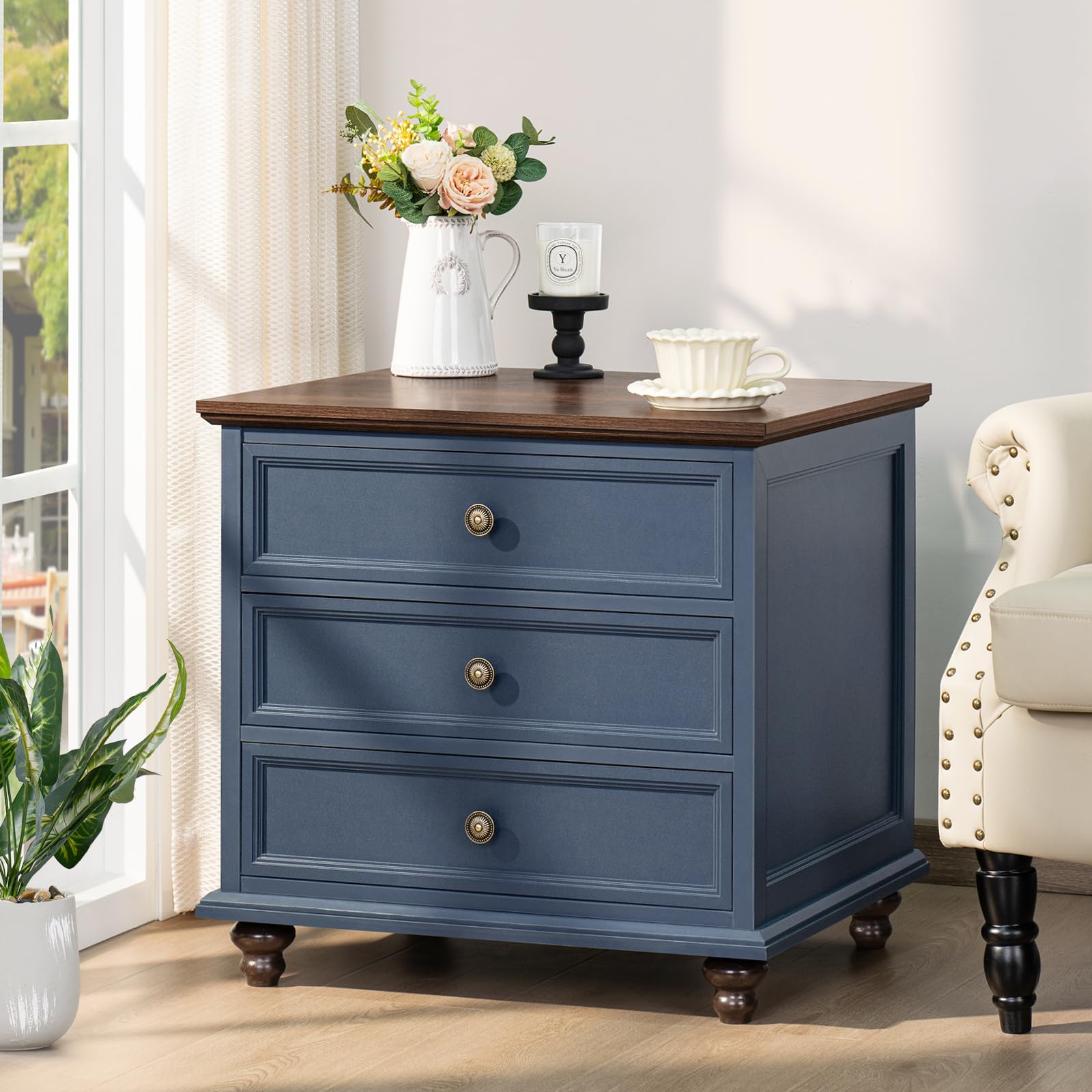 Blue nightstand with three drawers and round metal knobs in a living room setting