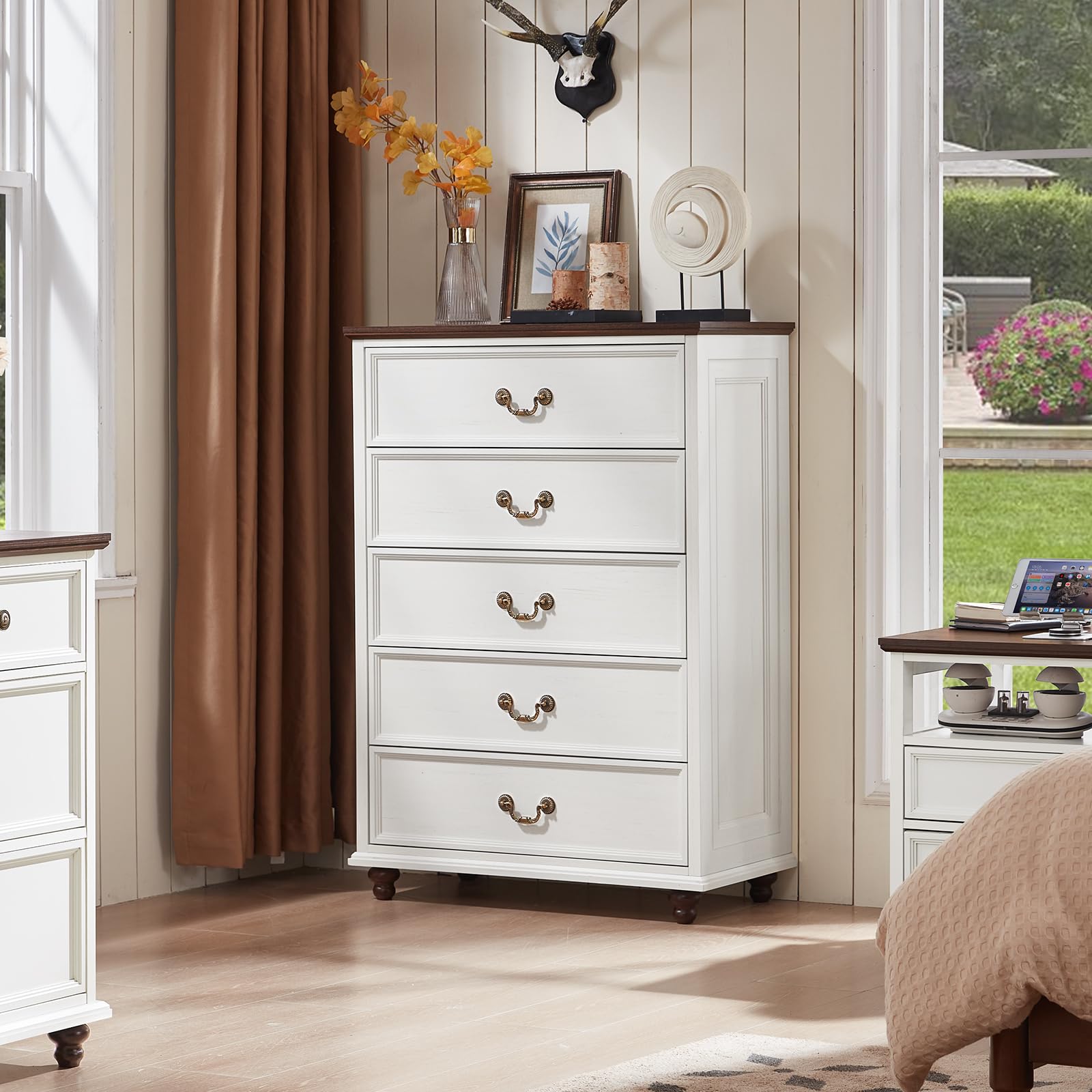 White dresser with multiple drawers, brass-tone pulls, and short wooden legs