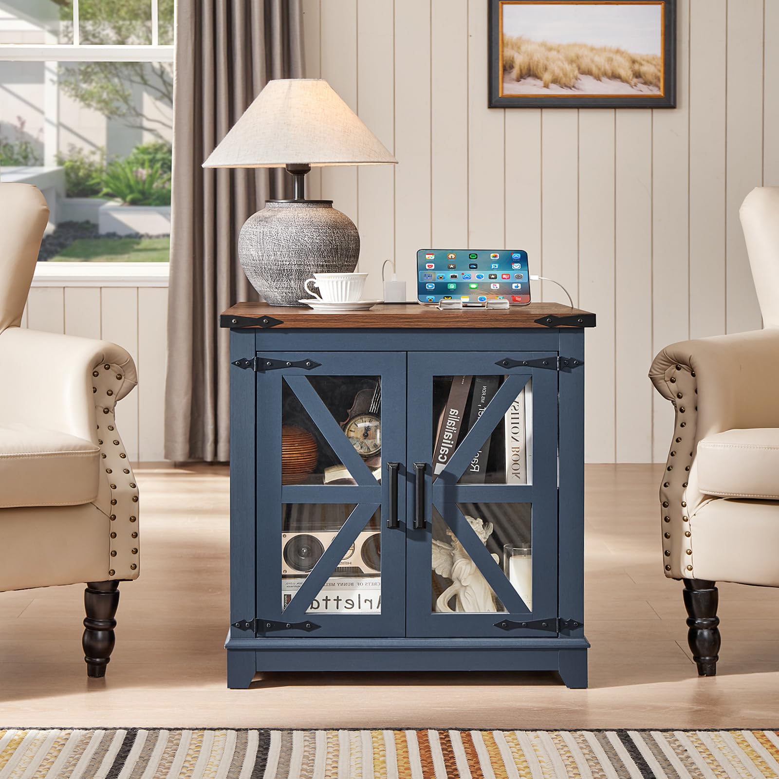 Farmhouse end table with glass barn doors and blue cabinet, lamp and devices on top.