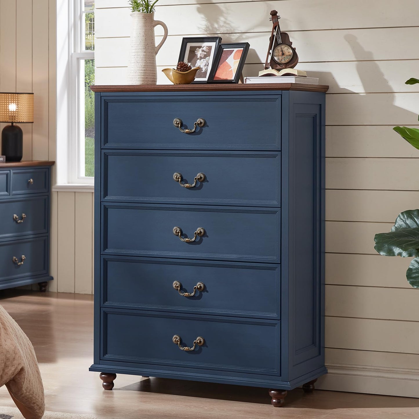 Navy blue 5-drawer dresser with brass knobs and four turned wooden feet