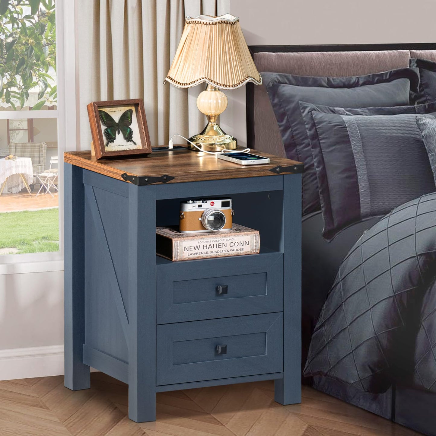 Blue nightstand with two drawers and open shelf, bedside lamp and book stack on top