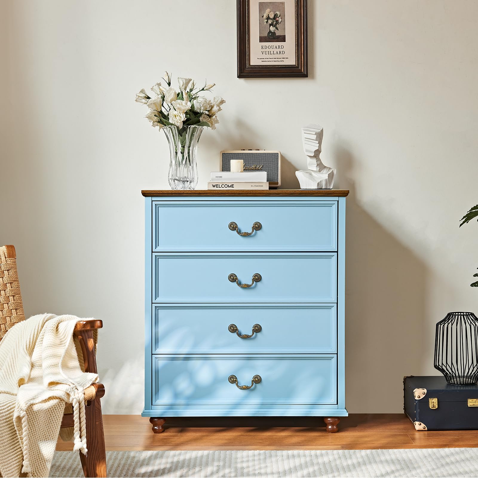 Blue dresser with three drawers and antique brass handles on wooden feet