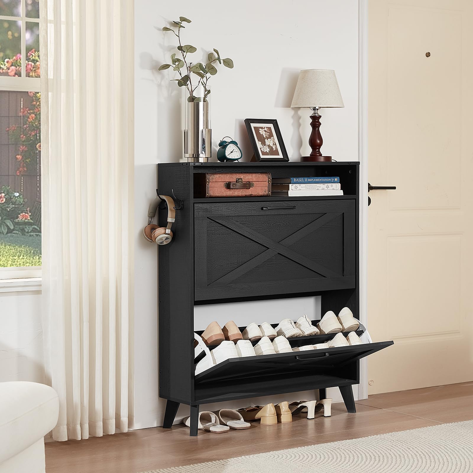 Black shoe cabinet with open flip drawer, interior shelves displaying pairs of shoes