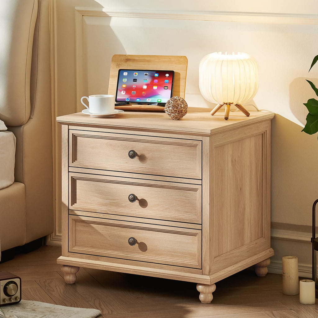 Light wood nightstand with three drawers and round metal knob pulls on legs