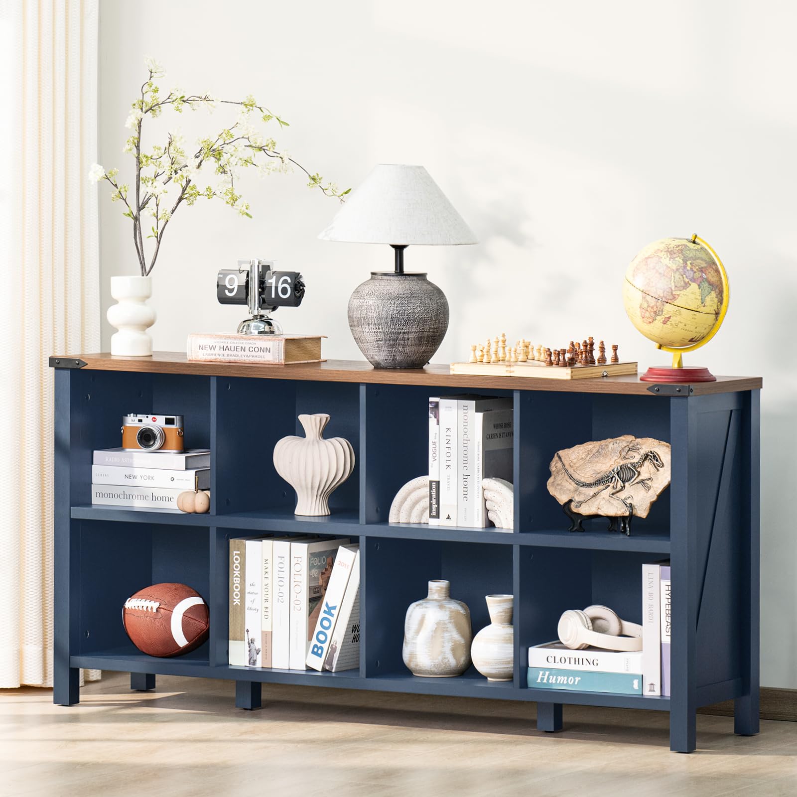 Navy blue console bookcase with open cubbies and legs, styled with books and decor