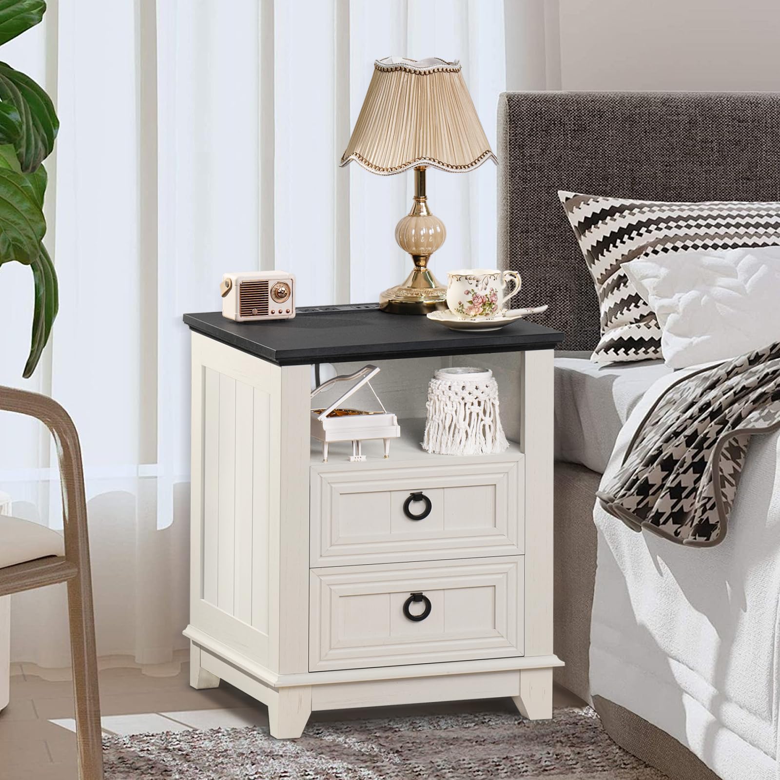 White nightstand cabinet with black top and two drawers with metal ring pulls