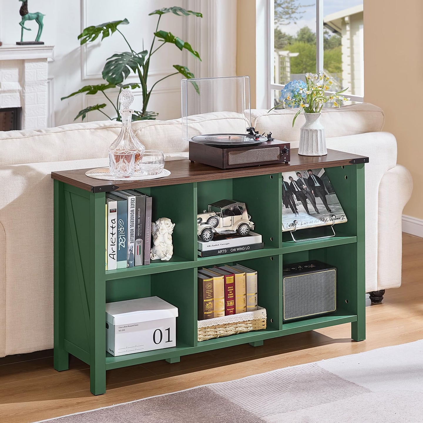 Green console bookcase with open shelves and cubby compartments on solid legs