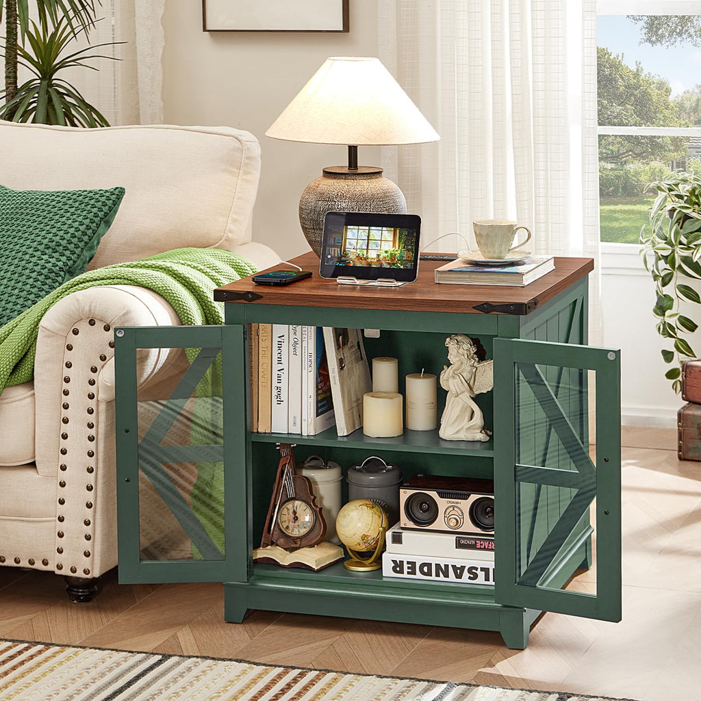 Green farmhouse end table with glass doors and open shelf, holding books and decor