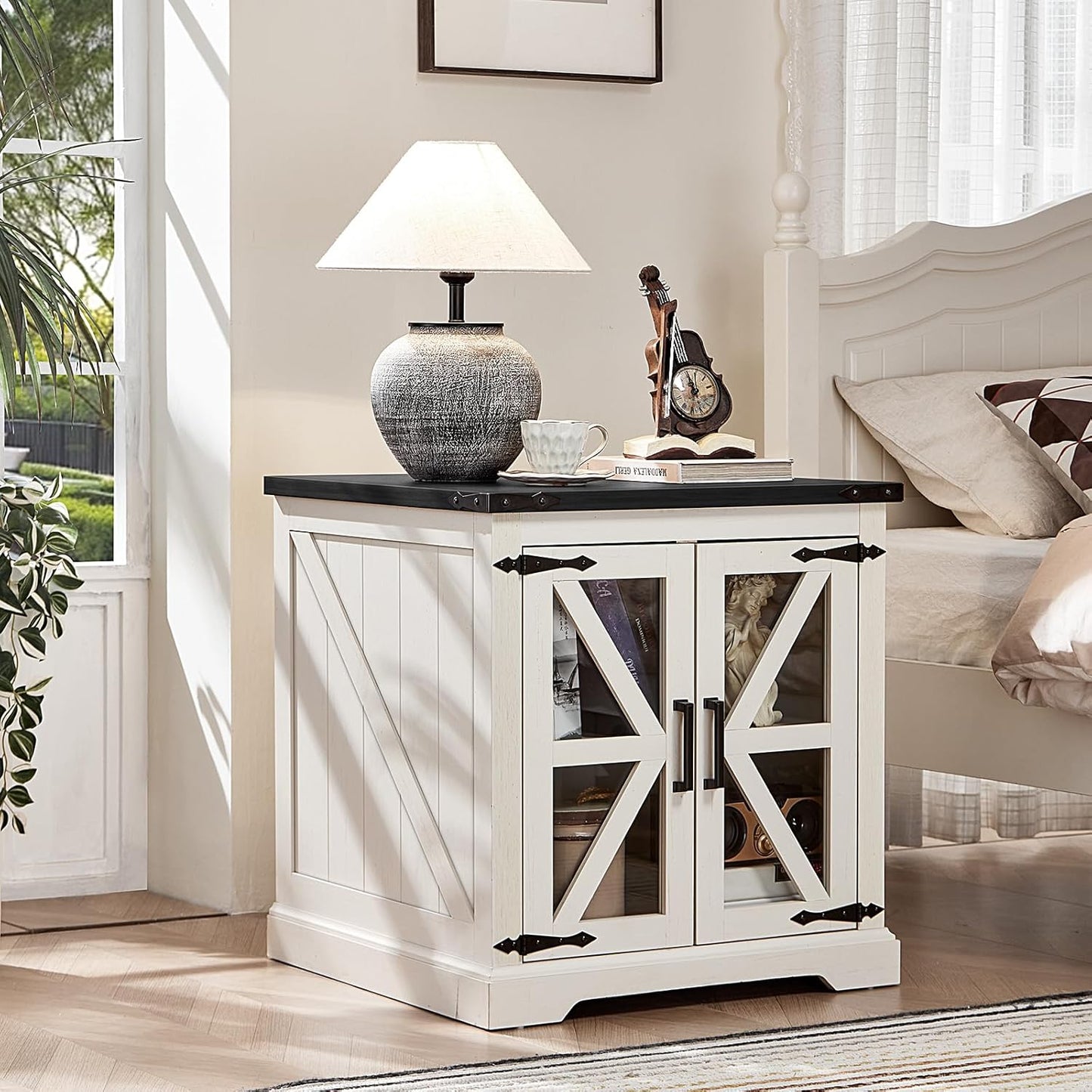 White nightstand with glass barn doors, black top, and built-in storage shelves.