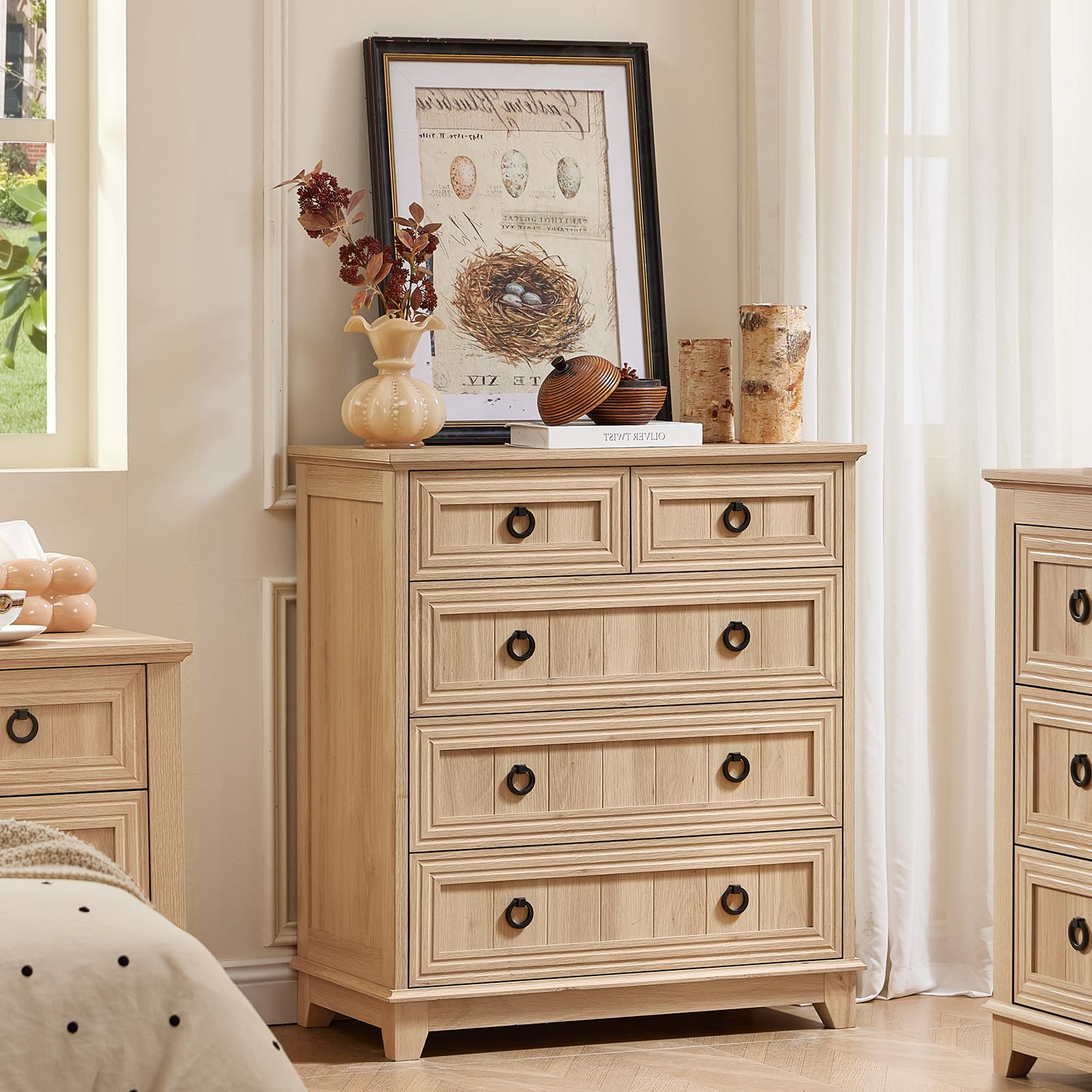 Natural wood dresser with five drawers and round bronze handles, panel detailing