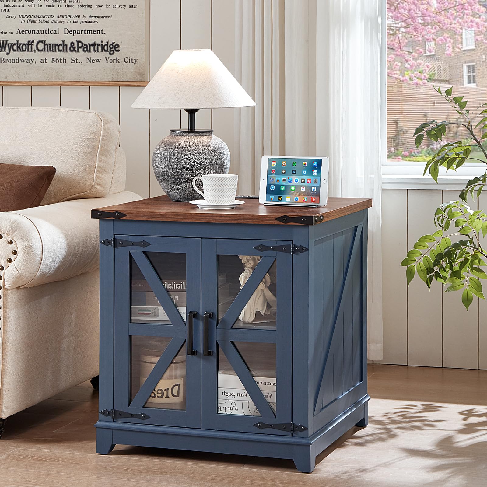 Blue farmhouse end table with wood top and glass barn doors, tablet on top
