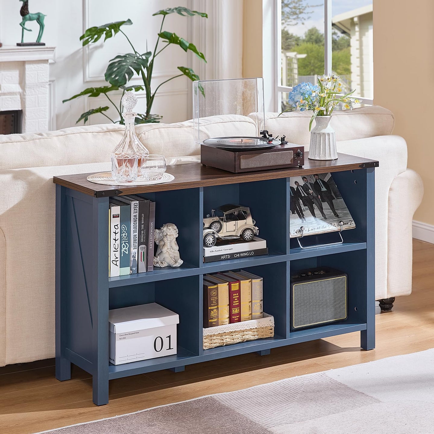Dark blue console bookcase with open cubby shelves and solid legs for books and decor