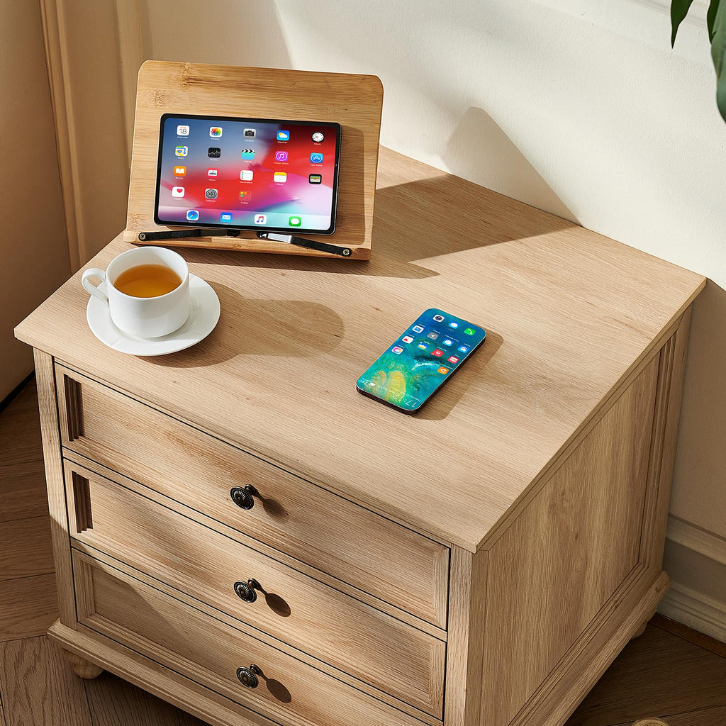 Light wood nightstand with three drawers and metal knob pulls