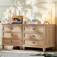 Farmhouse nightstand with natural wood finish, three drawers, round metal knobs and legs.