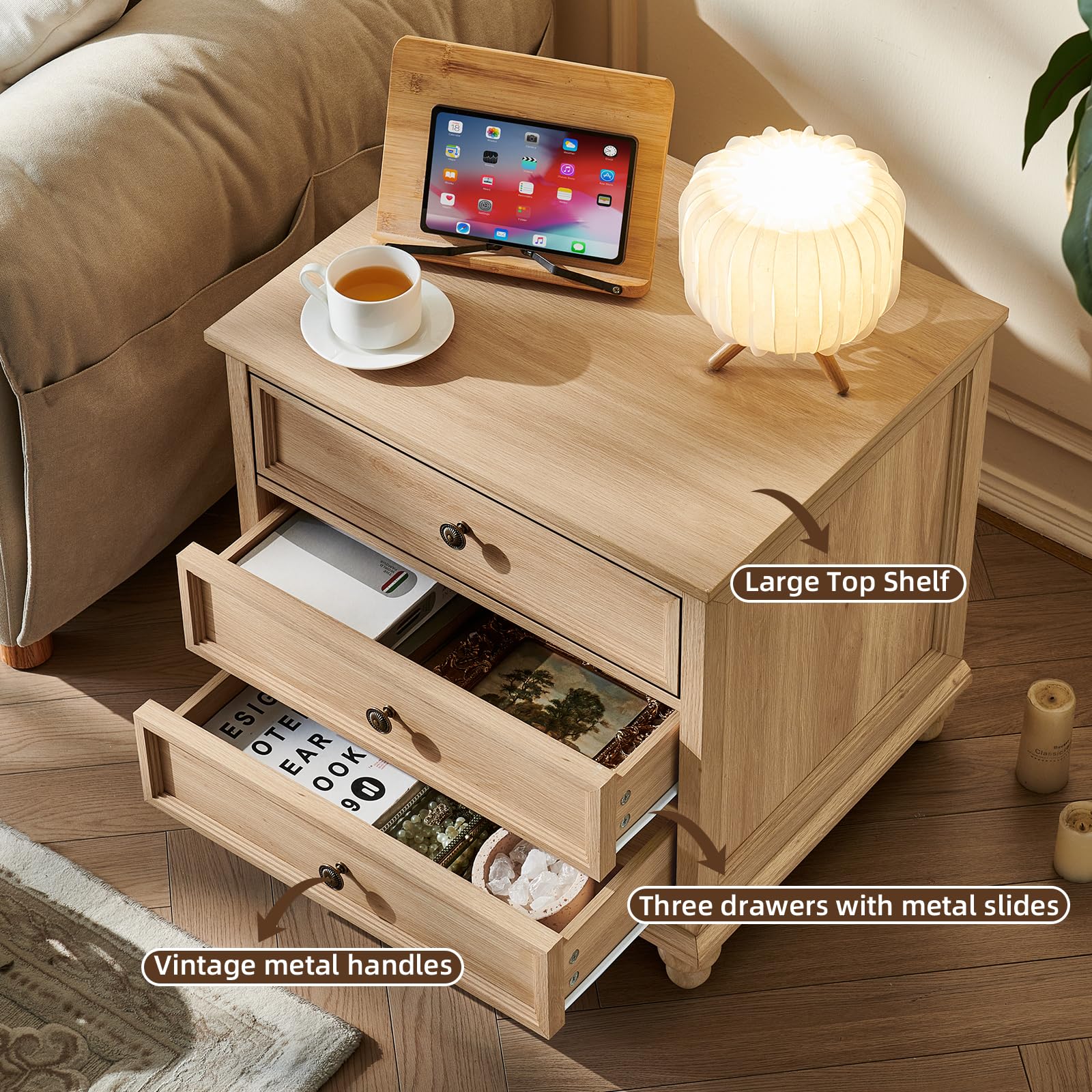 Light wood nightstand with three drawers, open storage and metal knob pulls