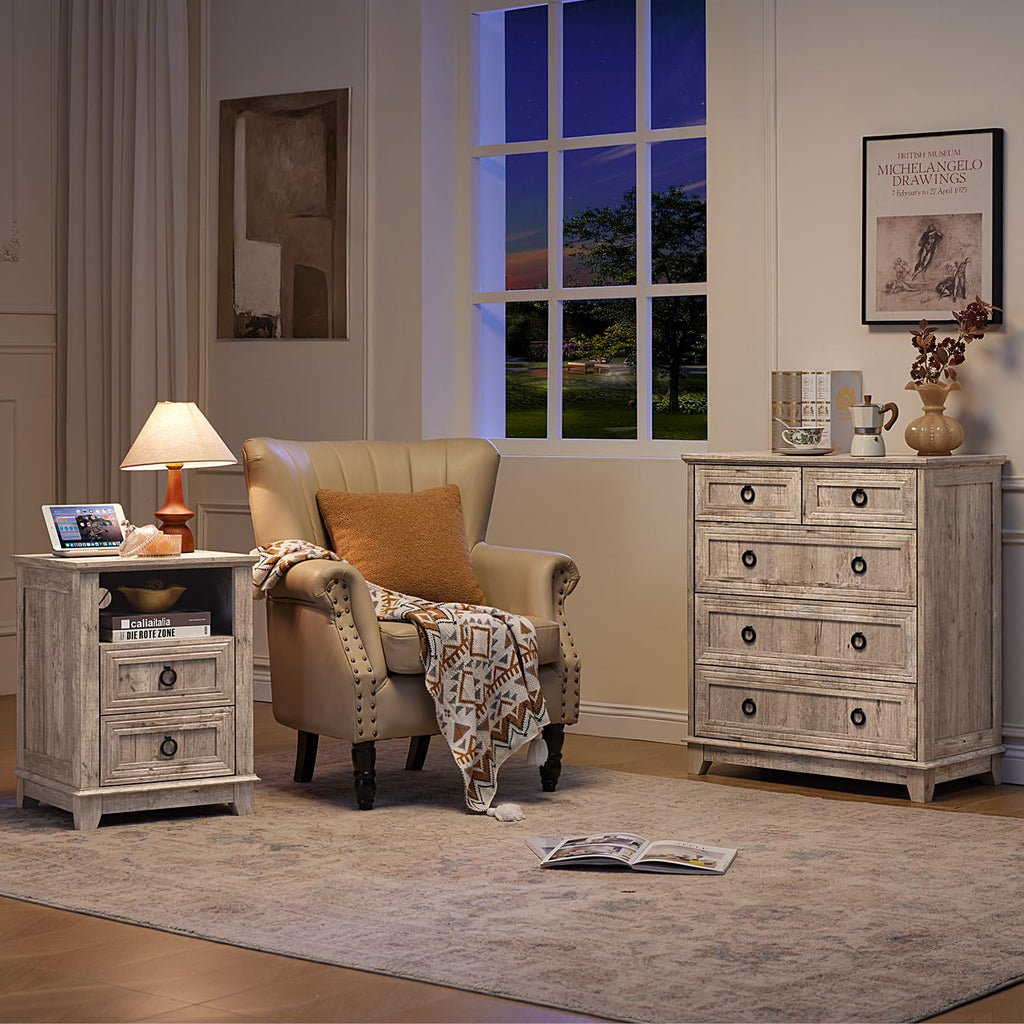 Gray dresser with five drawers and round metal knobs, displayed beside a living room chair