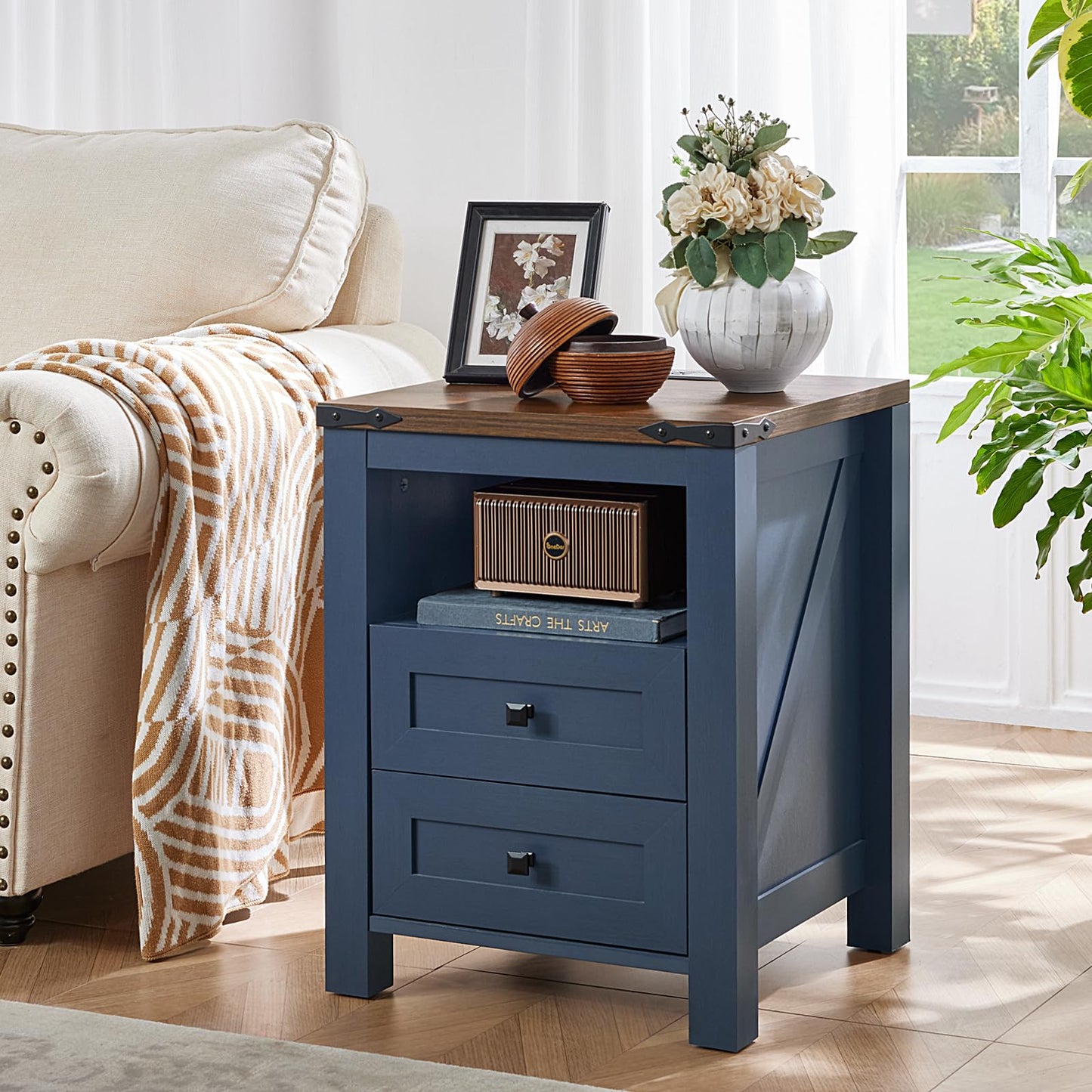 Blue nightstand with open shelf and two drawers, framed photo and flower vase on top