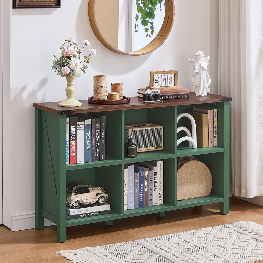 Green farmhouse bookcase with open cubbies and lower storage shelves, supported by legs