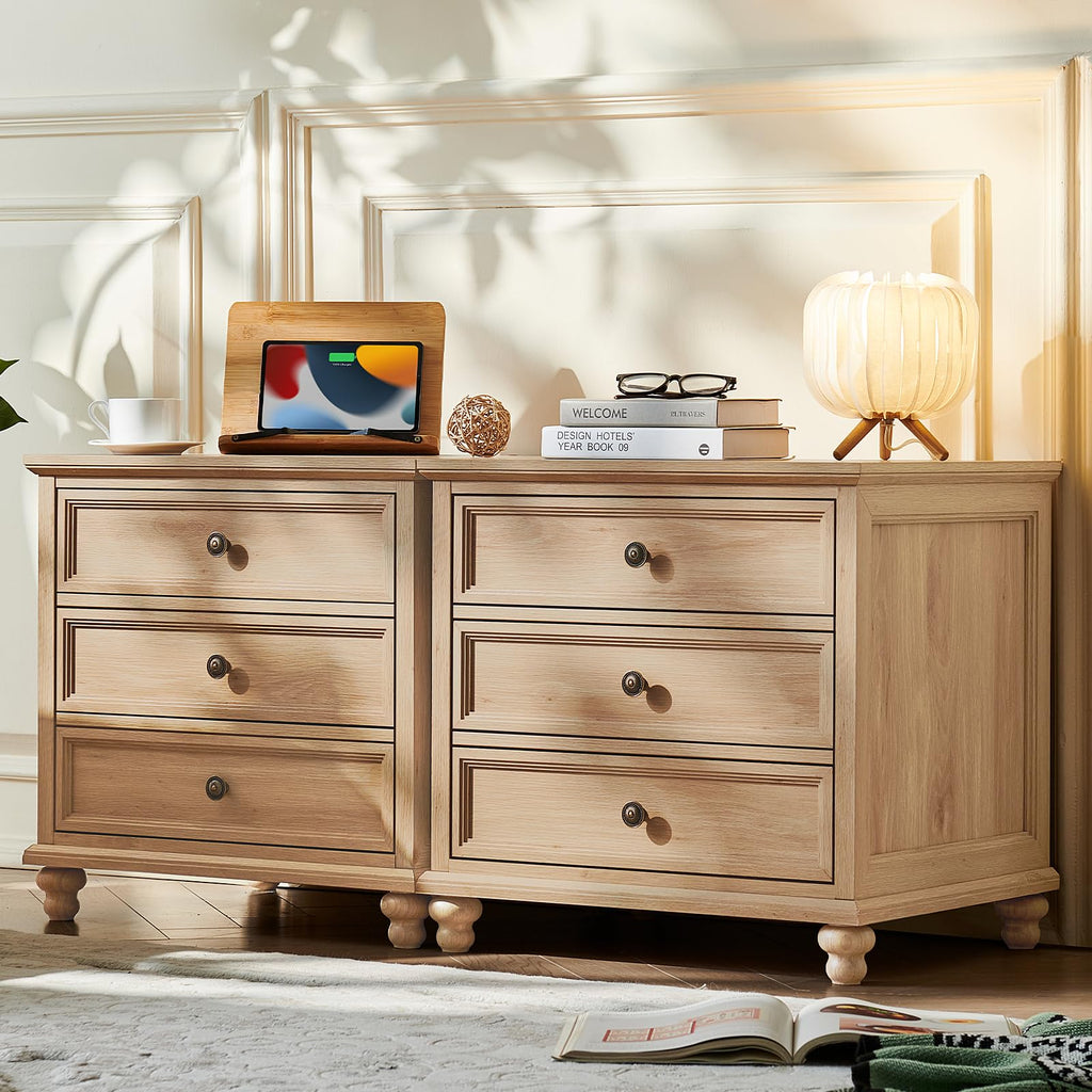 Light wood dresser with four drawers and curved metal pulls on turned feet
