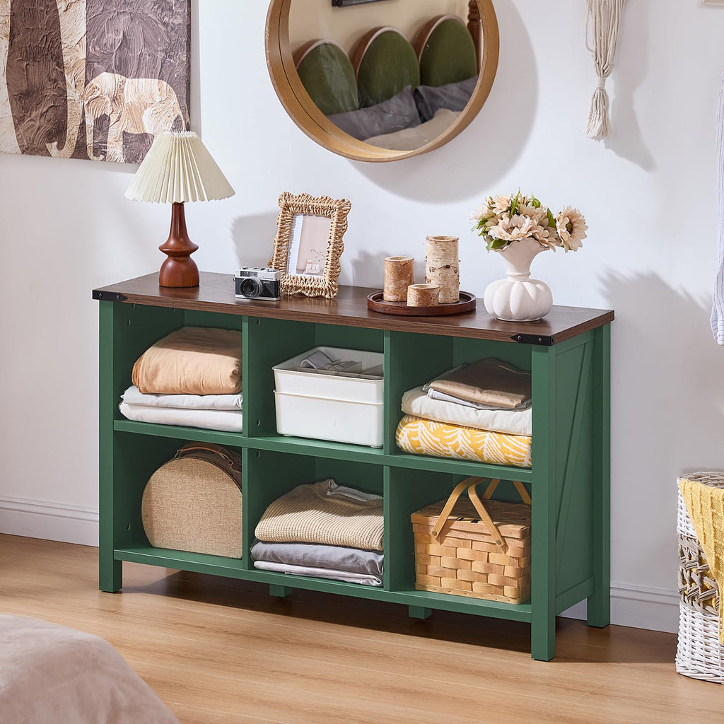 Green farmhouse-style bookcase with open cubby shelves, bin storage, and solid legs