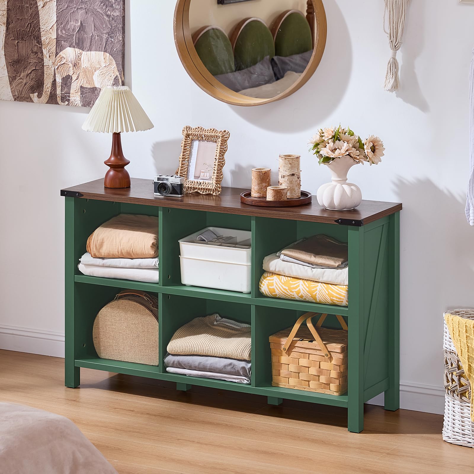 Green farmhouse-style bookcase with open cubby shelves, bin storage, and solid legs