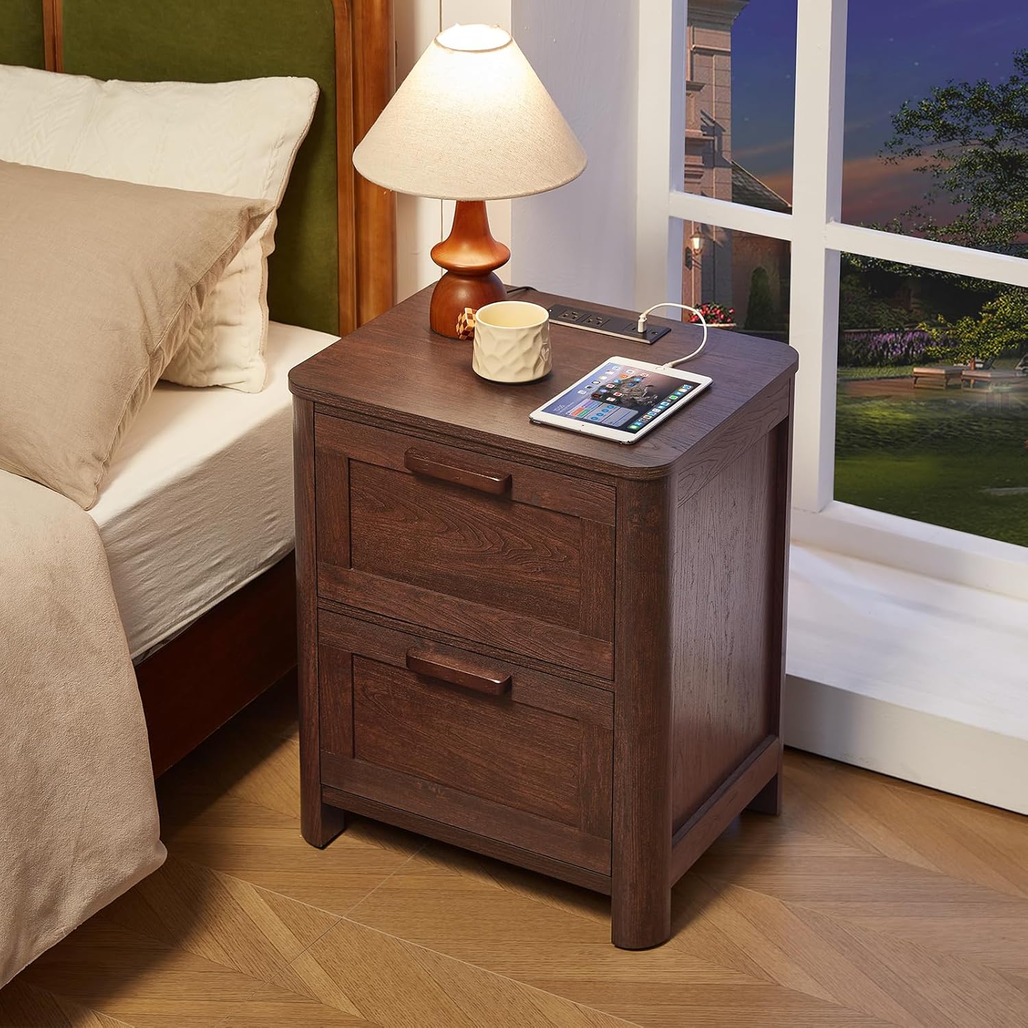 Walnut nightstand with two drawers and top charging station beside a lamp