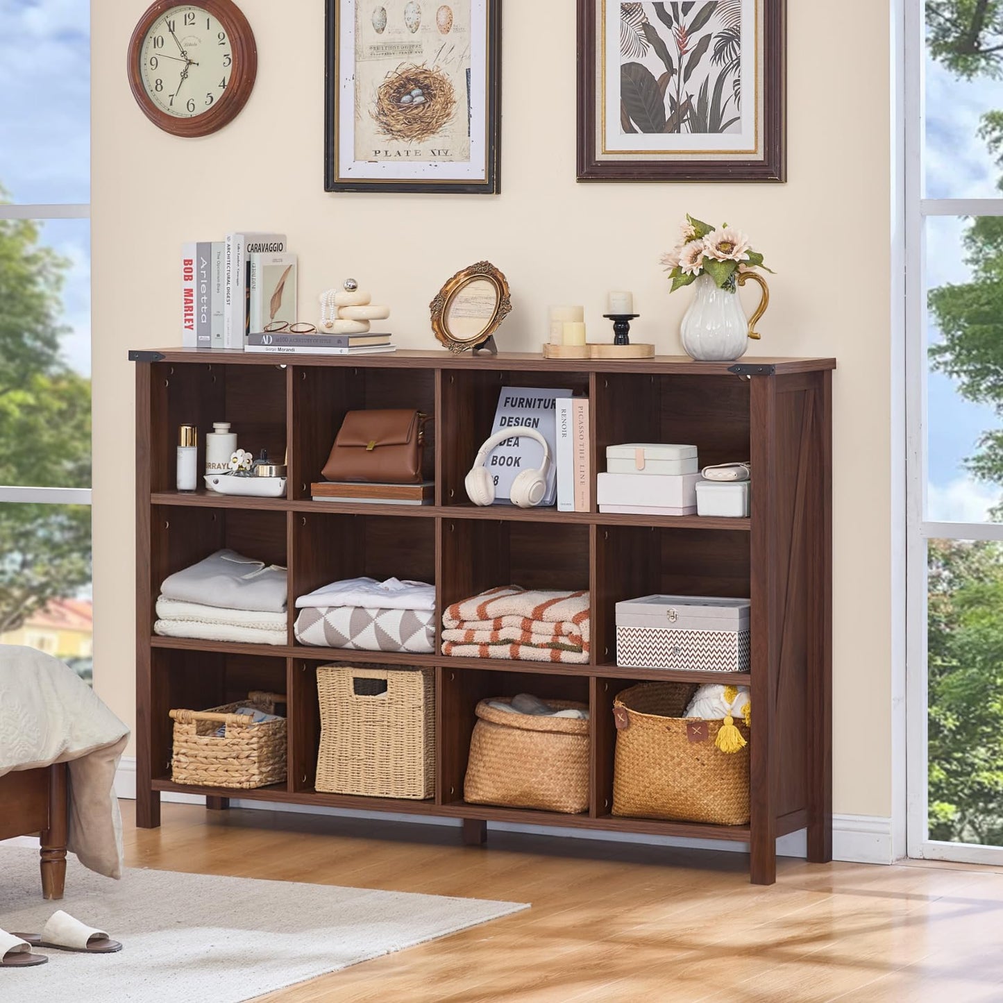 Brown bookcase with open cubbies and baskets, styled with folded textiles and decor