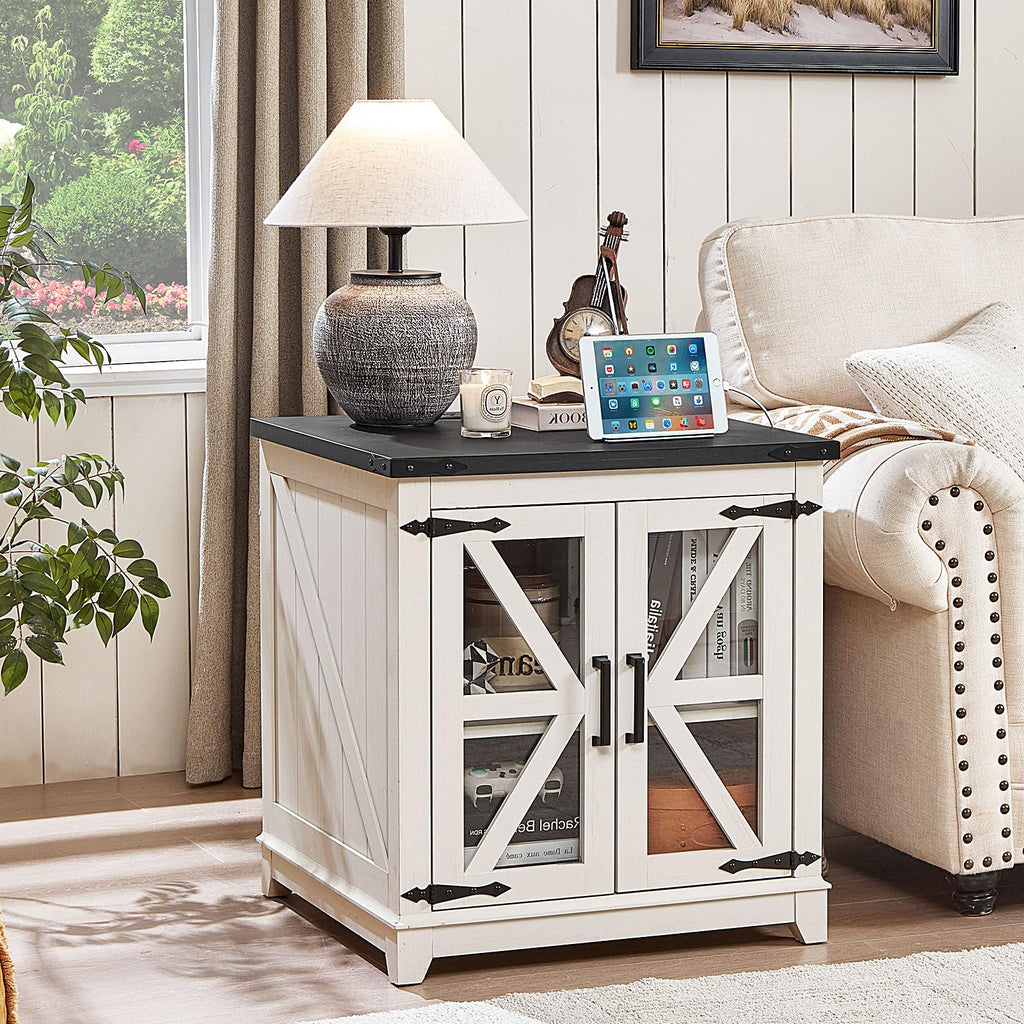 White farmhouse end table with black top and open storage shelves behind glass doors